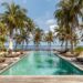 Indonesia resort swimming pool with lungers, beach view