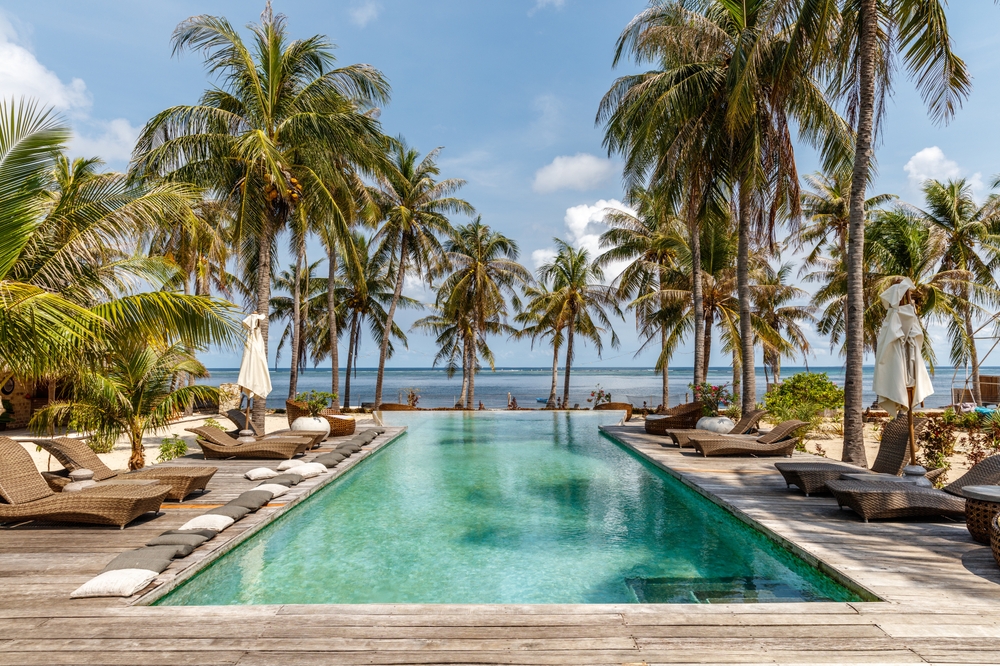 Indonesia resort swimming pool with lungers, beach view