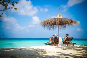 couple relaxing on tropical beach chairs