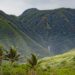 Molokai island, green mountain valley with waterfall in distance.