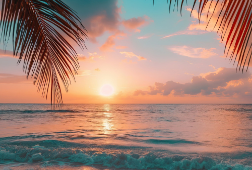Ocean sunset, blue, yellow, orange with palm trees leaves in foreground.