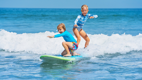 Young boy and girl surfing 
