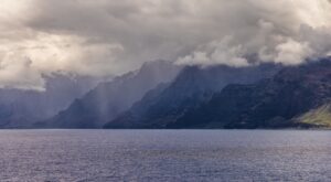 Rain clouds over jagged seaside cliffs in Hawaii