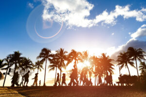 Silhouettes of people and palm trees walking on sidewalk