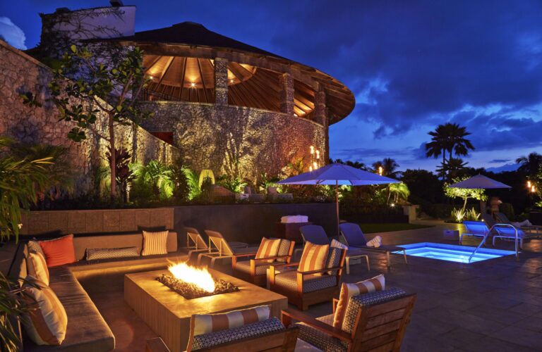 Hotel fire pit and lit up jacuzzi at night.