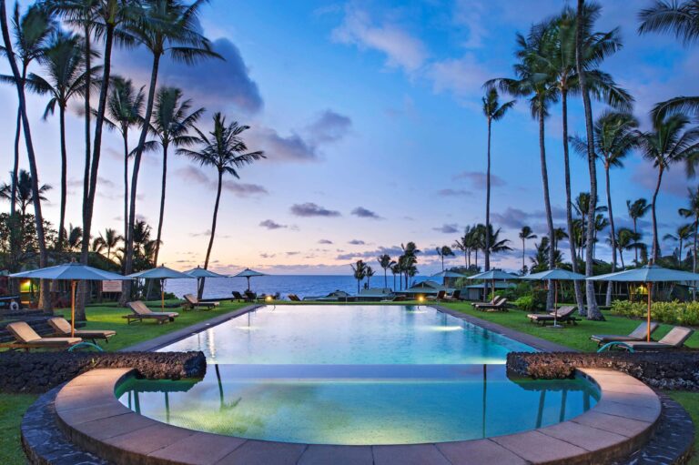 Hana-Maui Resort palm tree lined pool view looing towards ocean.