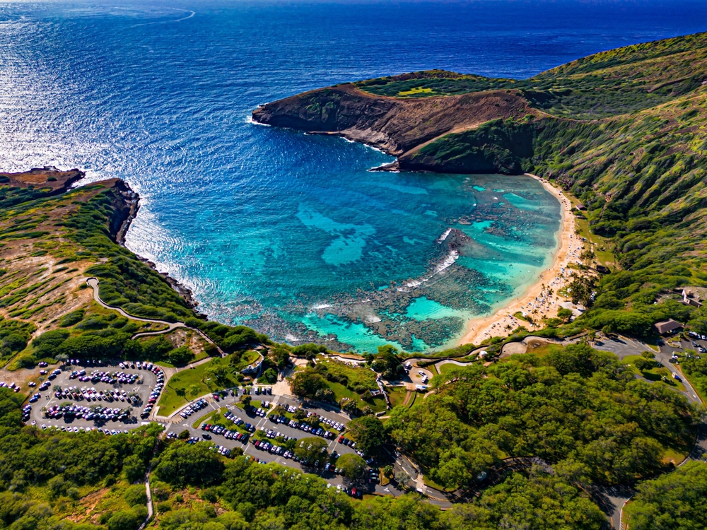Aerial view of green foliage crater bay with beach.