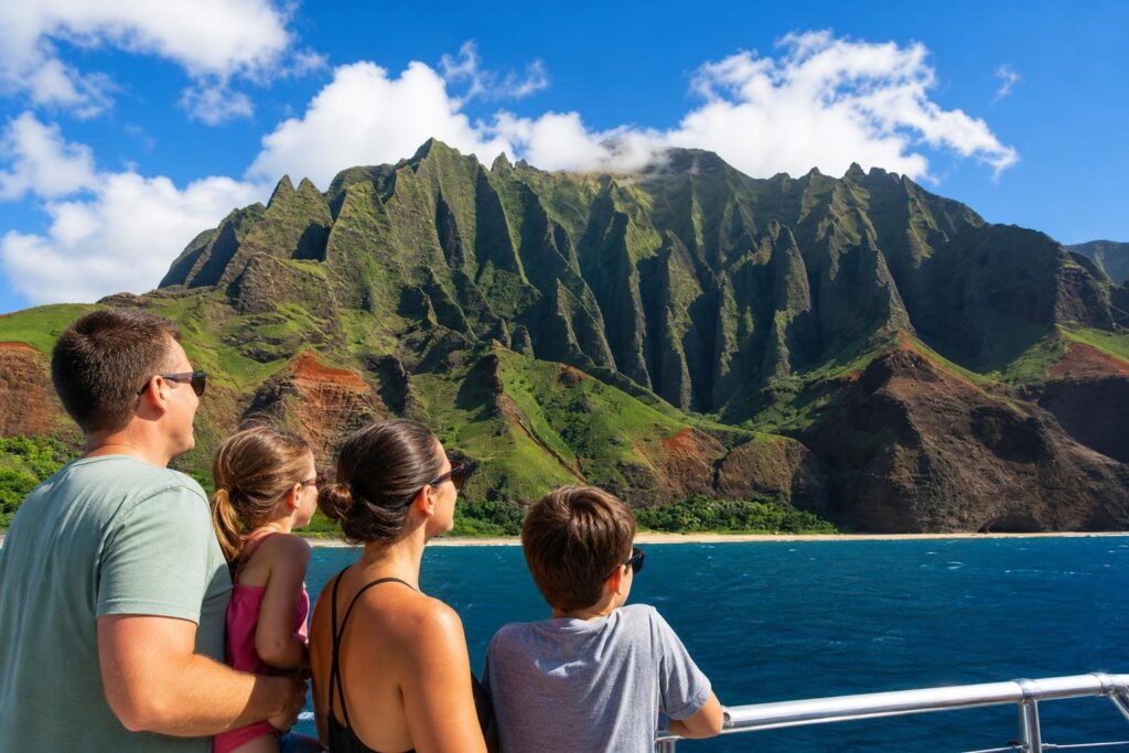 Family touring Na Pali Coast, Kauai, Hawaii on boat